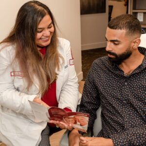 Seattle dentist shows her patient how to clean his teeth at Innovate Dentistry